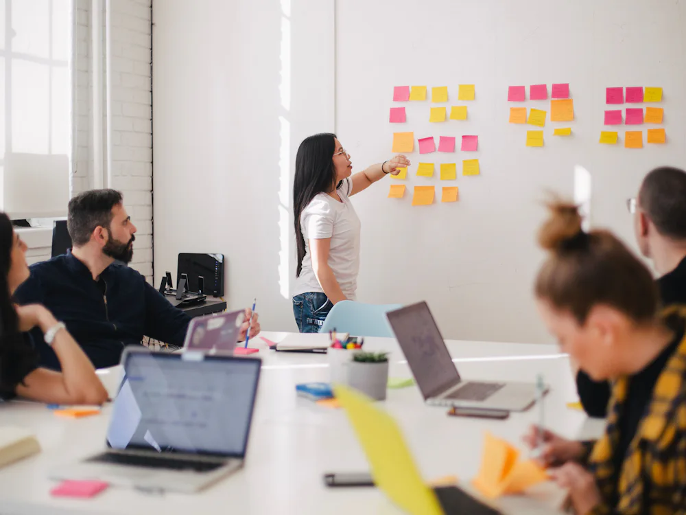Equipo de trabajo planificando una estrategia sobre una pizarra con notas